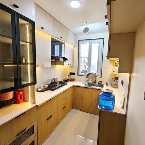 U-shaped kitchen with oak-laminate base cabinets, white upper units, a glass-front display cabinet, and under-cabinet lighting.