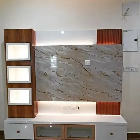 Under-fit-out TV unit wall with a marble-effect panel, backlit display niches and rust fluted-panel accents, wiring still exposed