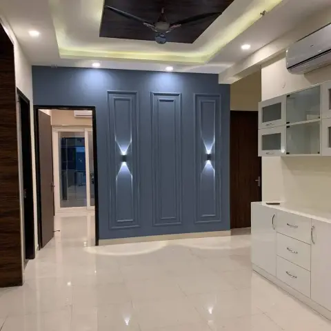 Unfurnished dining area with a slate-blue wall carrying three PU-moulded panels lit by two up-down wall washers
