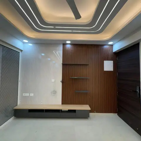 Unfurnished living room at handover with a walnut fluted TV wall carrying three slim floating shelves beside a beige marble-look panel