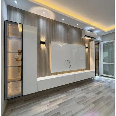 Unfurnished living room whose whole TV wall is beige fluted panelling, with a floating white gloss console