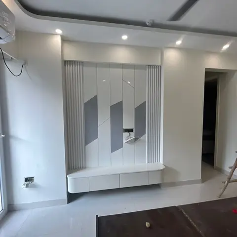 Unfurnished living room with a fluted-edge TV feature wall in a grey geometric panel pattern and a floating white console below