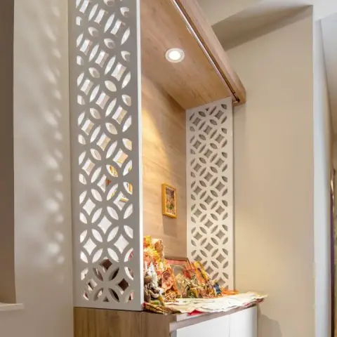 Wall-hung pooja unit in a corner - a wood-laminate back panel and hood with a single warm spot in the canopy