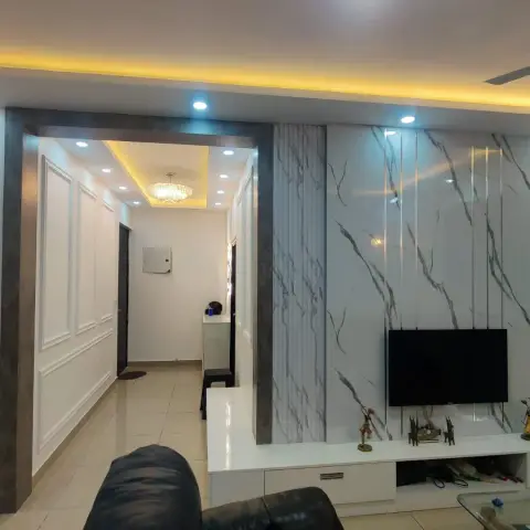 Wall-hung TV on a white marble-look slab-tile panel flanked by fluted white strips, over a low white drawer console