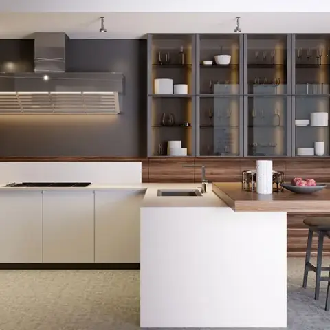 Walnut-clad tall unit run with built-in oven and coffee machine facing a white peninsula that steps down into an oak breakfast ledge with two grey stools