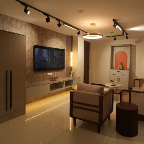 Warmly lit living room with a stone-print TV panel over an under-lit floating console, black track spots on the ceiling