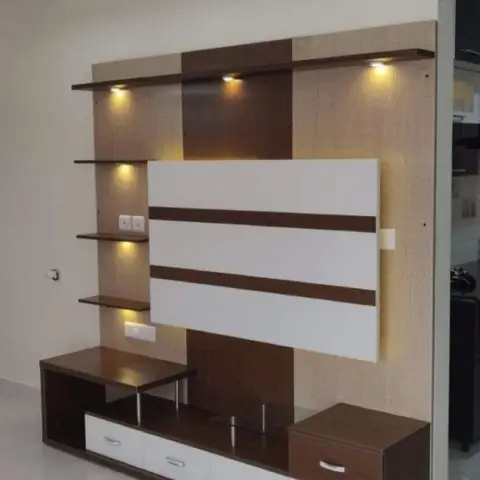 Wenge-and-white TV unit against a textured beige laminate back panel, with stepped glass shelves picked out by mini spots and a white centre panel banded in