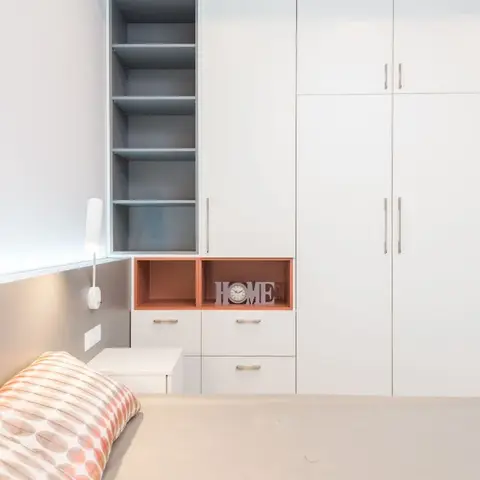White handle-bar wardrobe run with a duck-egg open shelf column and two coral-lined display cubbies holding a 'HOME' letter clock