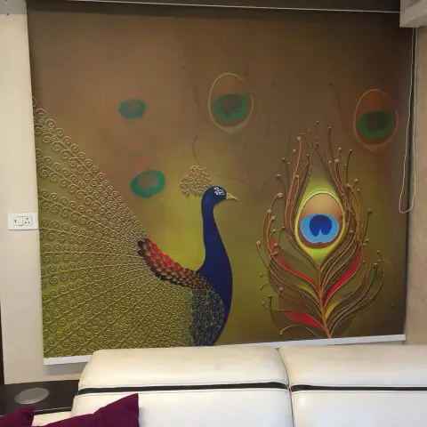 White leather sofa with magenta damask cushions set with its back to a full-width printed roller blind showing a blue peacock and an oversized peacock feather
