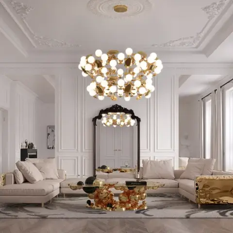 White panelled salon with an ornate plaster ceiling rose, a brass many-globe chandelier over two cream sectionals