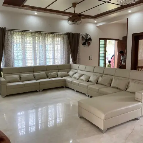 Wide family hall with an oversized U-shaped cream leatherette sectional and matching ottoman on mirror-polished marble