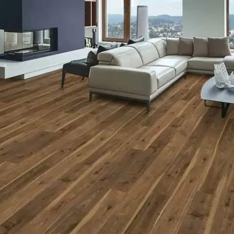 Wide walnut plank floor filling the foreground of a hillside-view living room with a beige leather sectional