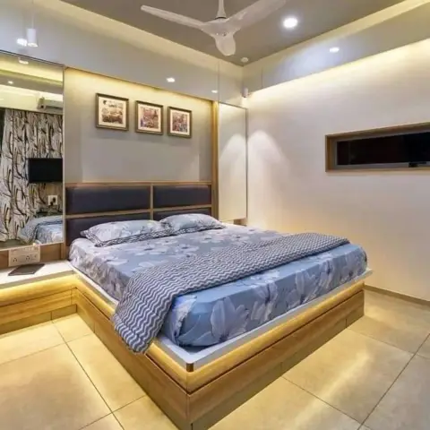 Wood-clad platform bed floating on an LED-lit plinth with a navy leatherette split headboard