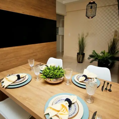 Wood dining table set with blue-and-white patterned plates and a black cage pendant light, white chairs