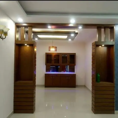 Wood-fluted partition columns with lit display niches frame the entry threshold, opening onto a glass-front crockery unit lit by blue LED accents.