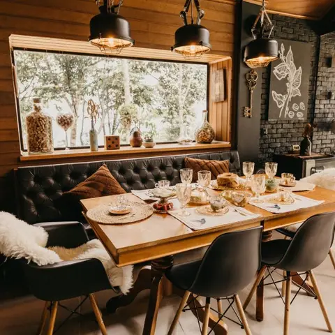 Wood-panelled dining nook with a built-in tufted leather bench, industrial pendant lights