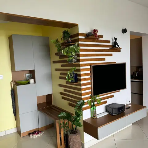 Wood-slat feature wall doubles as an entrance nook with a shoe cabinet and umbrella stand on one side and a floating TV console styled with potted plants on