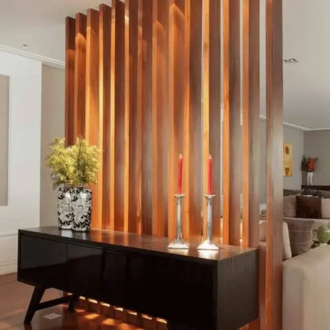 Wood-slat partition screen separating the entrance from the living room, with a black gloss console table styled with a patterned vase and silver candlesticks.